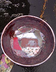 Abstract raku bowl with stained glass in bottom. Still wet after firing   